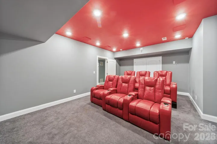 Enjoy the ultimate cinematic experience in this dedicated home theater, complete with tiered seating and built-in surround sound for immersive movie nights.