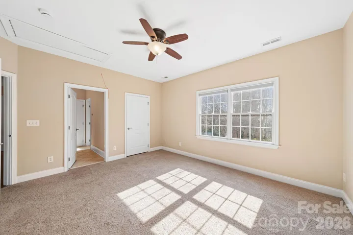 Bright and versatile bedroom featuring large windows and elegant crown molding—perfect as a guest suite, office, or additional living space.