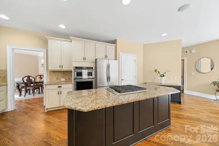A stunning oversized island anchors this gourmet kitchen, complemented by stainless steel appliances and abundant prep space—perfect for hosting family gatherings or intimate dinner partie