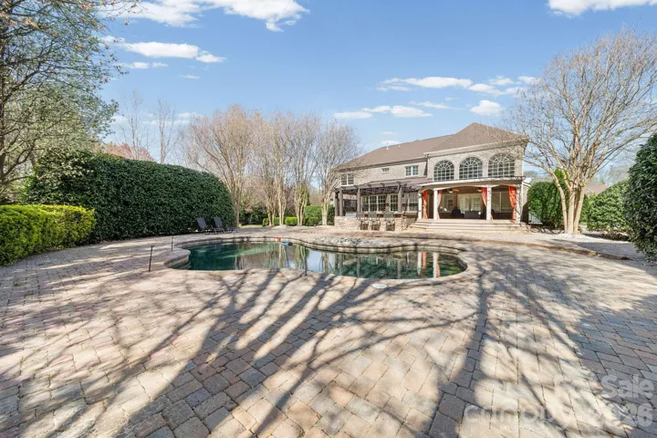 Custom outdoor kitchen under a stunning pergola, complete with stonework detailing—perfect for al fresco dining and year-round entertaining