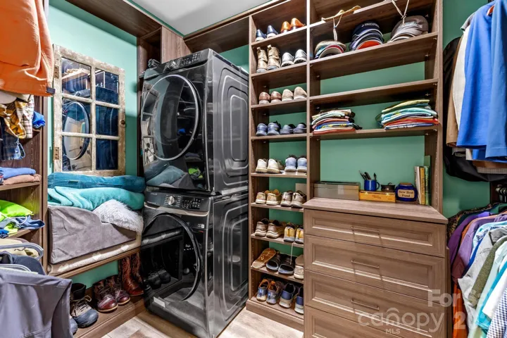 One of two of the large walk-in closets found in the primary bedroom, this is where the washer and dryer are located.