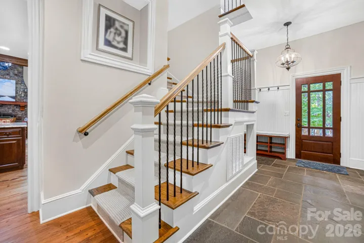 The functional drop zone area by the “friend’s door” boasts a custom bench  for shoes and a niche with storage for backpacks is complemented by a spacious coat closet.