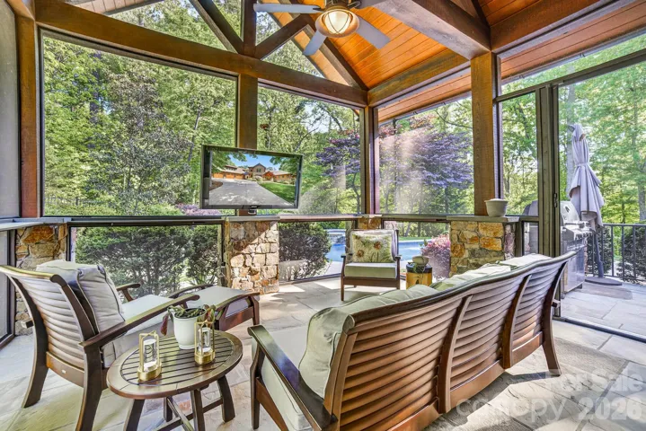 The screened in back porch with vaulted ceiling and cedar beams, bluestone flooring, ceiling fan is an owner favorite for football watching gatherings, and spending lots of time throughout the year!