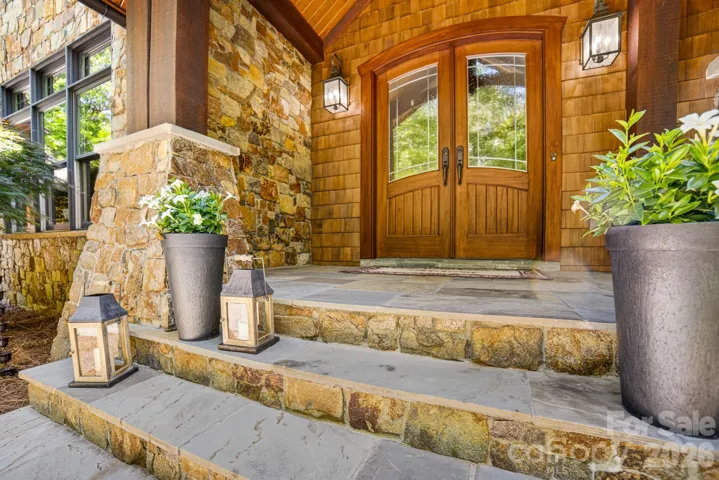 Appreciate the WOW factor with the impressive custom Sapele mahogany double front doors (handcrafted in NC), bluestone porch and vaulted beadboard ceiling.
