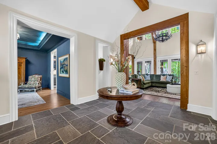 Venture into a dramatic vaulted foyer with bluestone flooring and cypress beams which leads to the spectacular vaulted Great Room, featuring massive hammer-beam trusses and custom Alderwood built-ins with teardrop glass cabinetry.