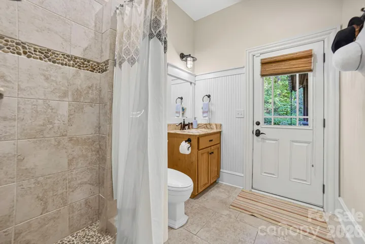 A cabana bath with shower and soothing pebble stone s was designed for easy access to the backyard and pool area.
