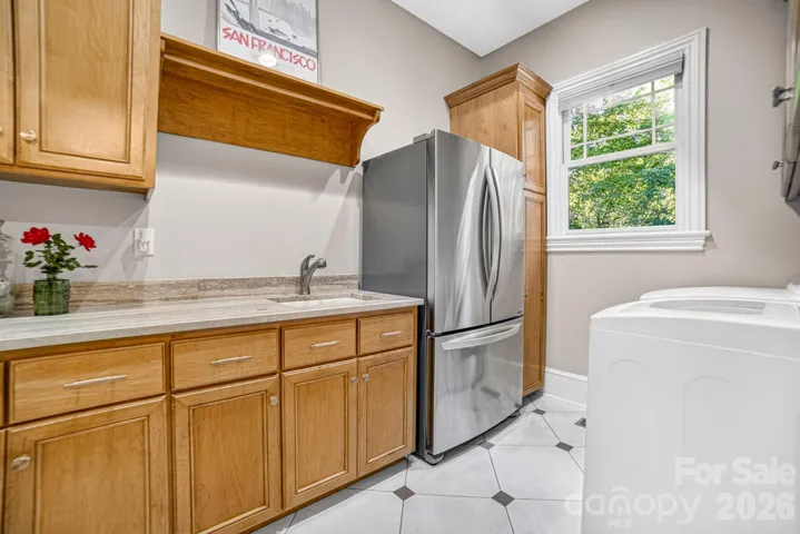 The laundry room includes a soap stone counter, laundry chute and has room for a refrigerator. It also includes a closet under the stairs for extra storage. The washer and dryer will convey to the buyer.