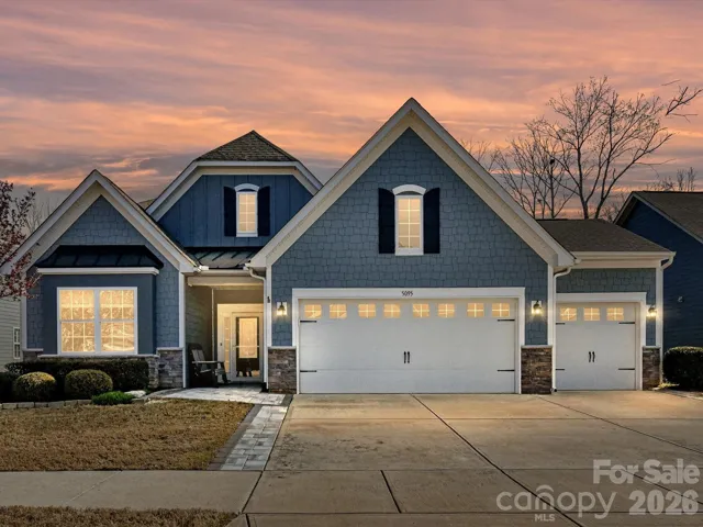 "Twilight View" of Home Exterior with Fiber Cement Exterior enhanced with Stone Accents. Stone Pavers added to both sides of Driveway and Entry. Stone Edging at Landscaped Beds