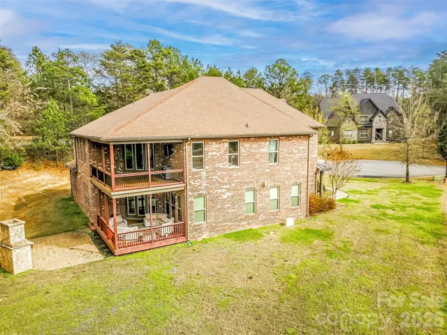Exterior view of the rear and side of the home with two covered decks.