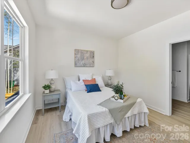 Spacious and light-filled primary suite featuring large windows, neutral finishes, and a comfortable layout perfect for rest and relaxation.