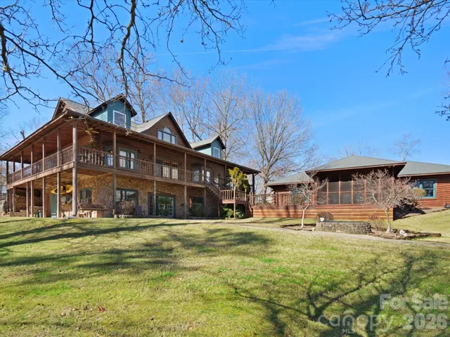 Beautiful 3-level custom log home with covered porches around entire home - notice the huge screened-in porch attached to the detached 4-car garage with views of the lake.