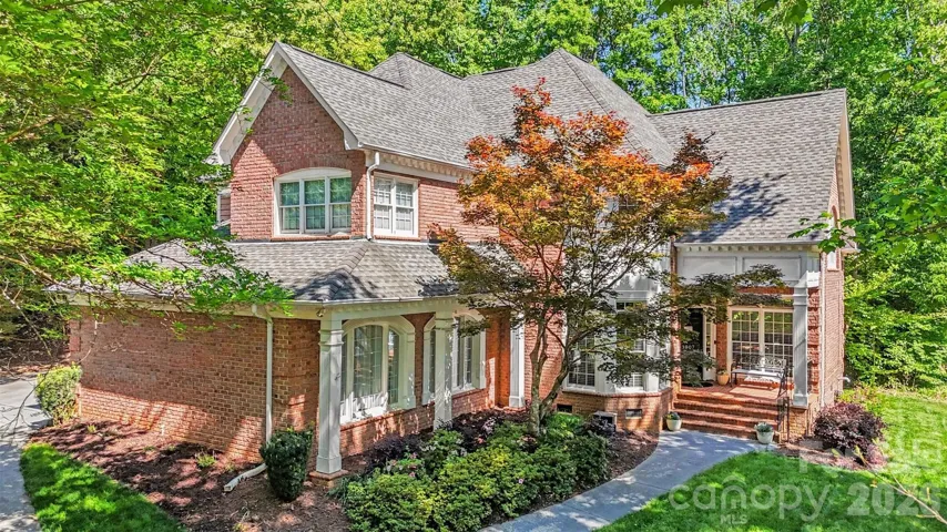 Front exterior framed by mature trees