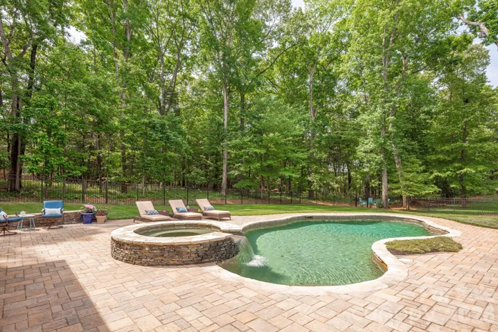 Picturesque salt-water pool and spa is surrounded by nature in this wooded retreat