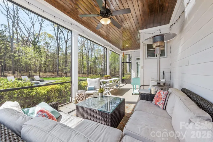 Tranquil screen porch with tongue and groove stained ceiling and ceiling fan. 
