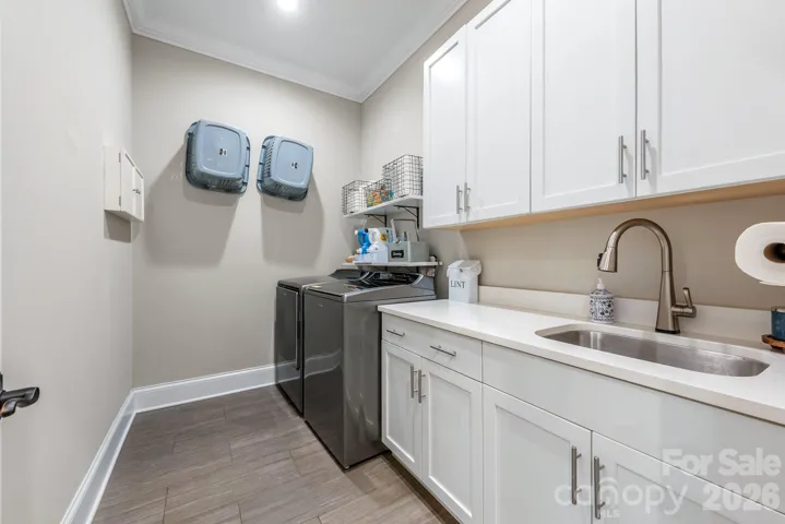 Laundry includes high efficiency top-load washer, dryer, utility sink, and lots of storage.