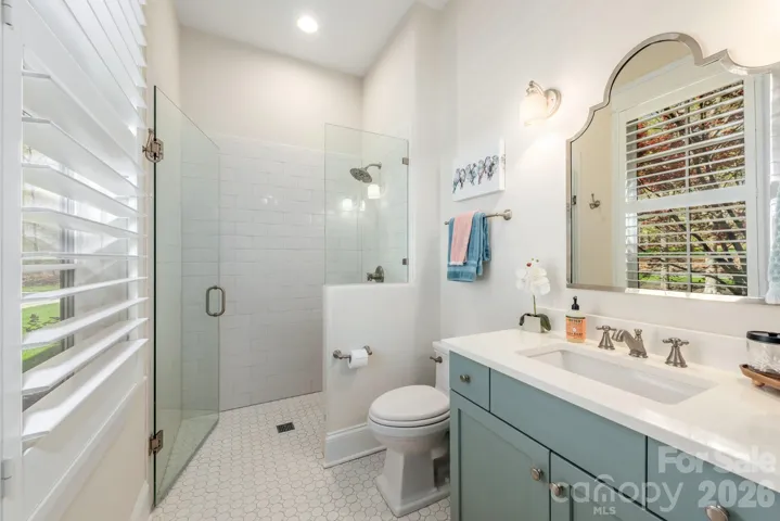 Guest en suite bath features zero-entry shower for seamless access. 
