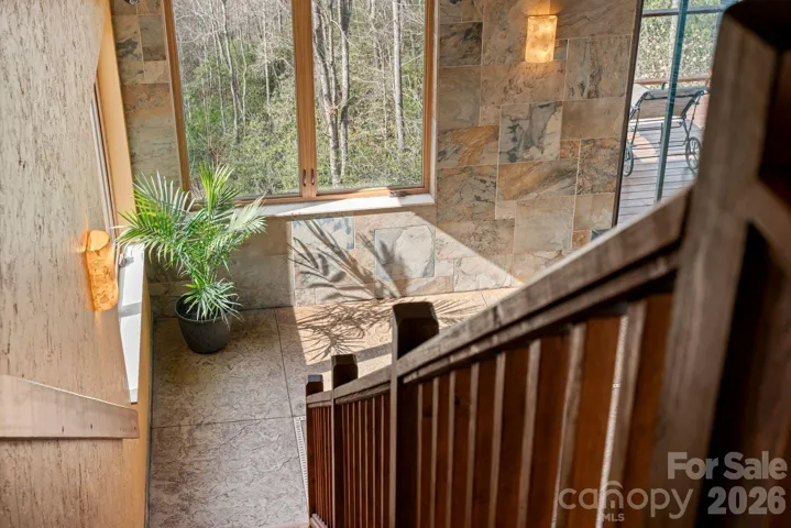 view from top of private stairs leading down off primary to indoor pool/spa