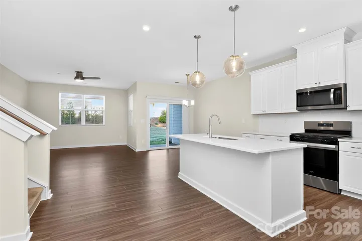 Bright kitchen with upgrades galore--pendant lights, tall cabinets, upgraded countertops