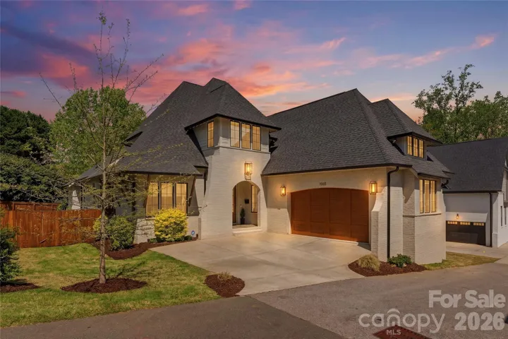 Stunning custom-built residence showcasing timeless architecture, warm natural materials, and elevated curb appeal with a striking front elevation and designer lighting.