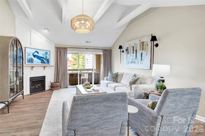 Lving Room with vaulted ceiling and sliders that lead onto a covered deck.