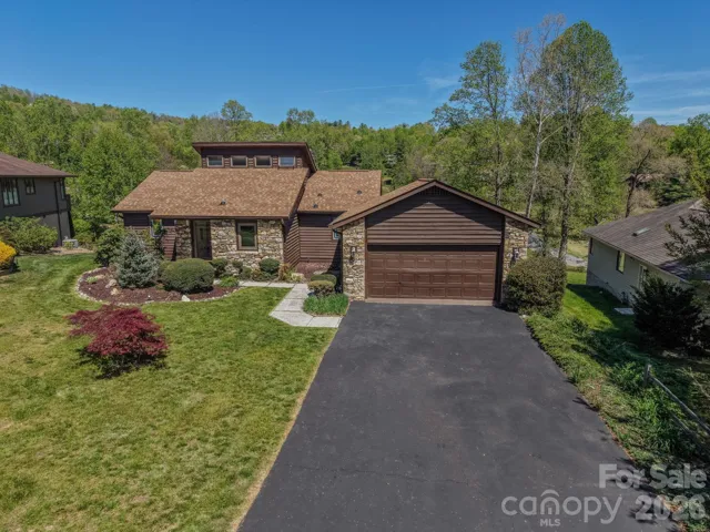Front aerial view showcasing the home’s setting, layout, and surrounding landscape.