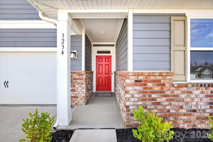 Covered front stoop with beautiful red door that pops!