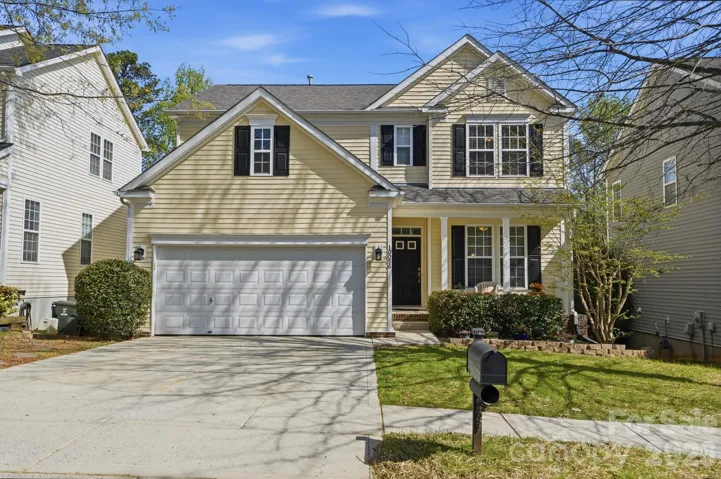 Front exterior. Lawn is growing in, clean hedges, stone path to backyard along left side of home.