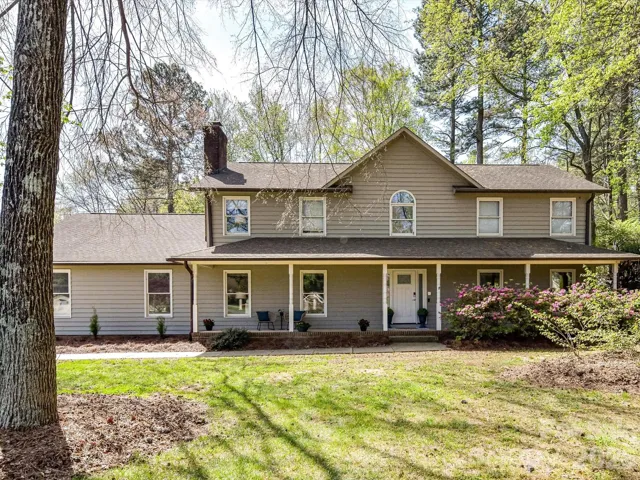 Charming two-story home with a welcoming, expansive front porch, located on nearly a 1 acre lot with 3 car attached, side load garage, surrounded by mature trees and lush landscaping for a peaceful, private setting.
