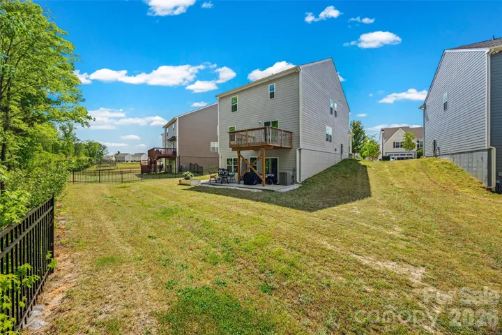 Level, cleared yard backing to mature trees
