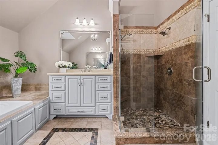 Primary spa bathroom with double vanities, shower and garden tub