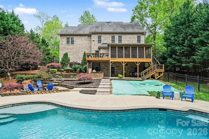 Magnificent back yard with multiple areas to entertain and enjoy: pool, spa, fire pit, patio, covered porch