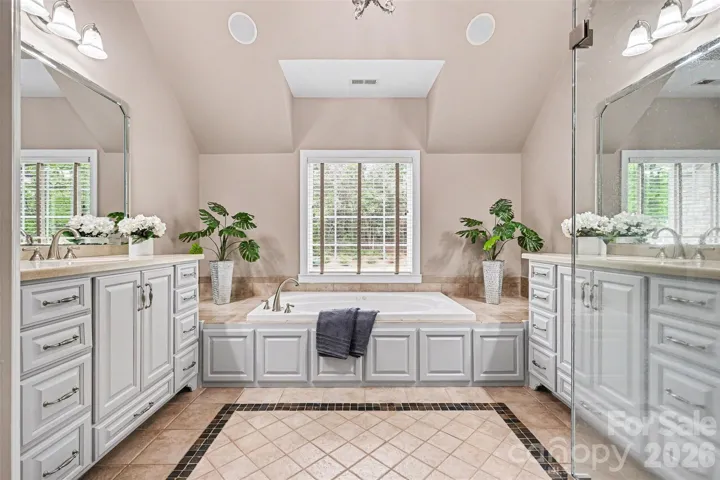 Primary spa bathroom with double vanities, shower and garden tub