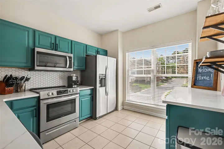 Updated kitchen featuring modern finishes, abundant natural light from large windows, and an inviting open-concept living space.
