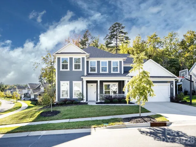 Charming two-story home with inviting front porch, manicured landscaping, and excellent curb appeal in a desirable neighborhood.
