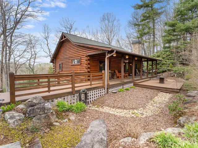 Front Exterior & Covered Deck – Classic log cabin exterior with a spacious covered front deck, offering a welcoming entry and a great place to relax and take in the natural surroundings.