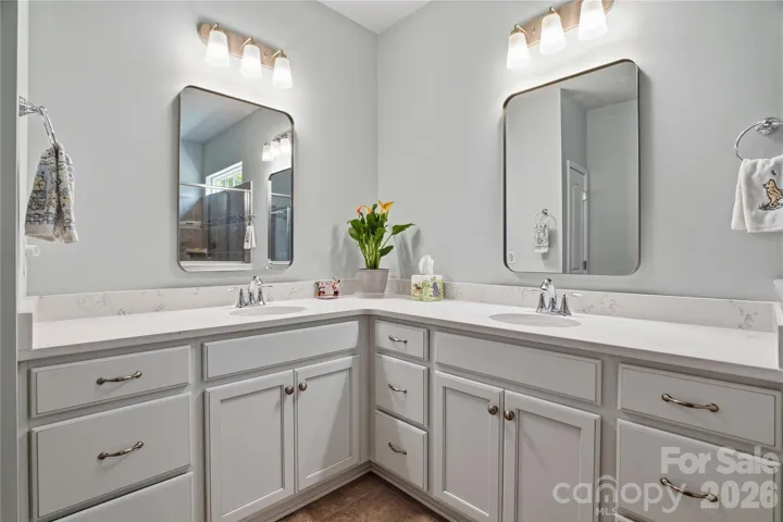 Dual vanity sinks with updated mirrors and quartz countertops