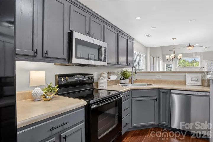 Stainless and black appliances with painted cabinets and upgraded hardware. 
