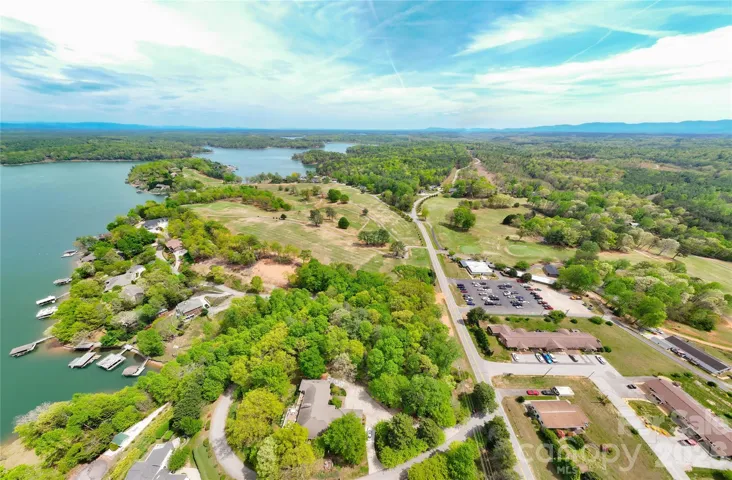 Long range drone aerial view of nearby golf course and Lake James