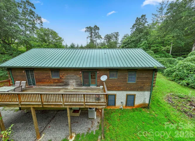 Rear exterior view highlighting the elevated deck and peaceful backyard setting.