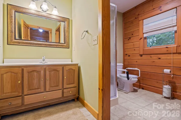 Spacious bathroom with dual vanity, rustic wood accents, and convenient walk-in shower.