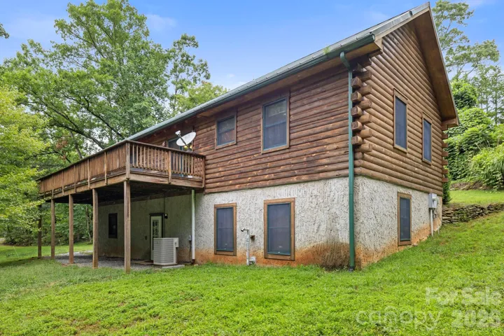 Elevated deck overlooking the wooded surroundings, ideal for outdoor dining or enjoying the natural setting.