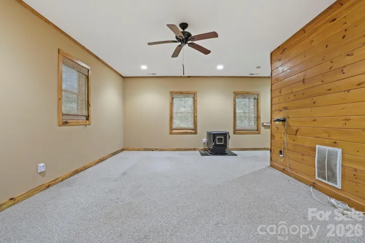Expansive lower-level living area with cozy stove, perfect for a recreation room, media space, or guest retreat.