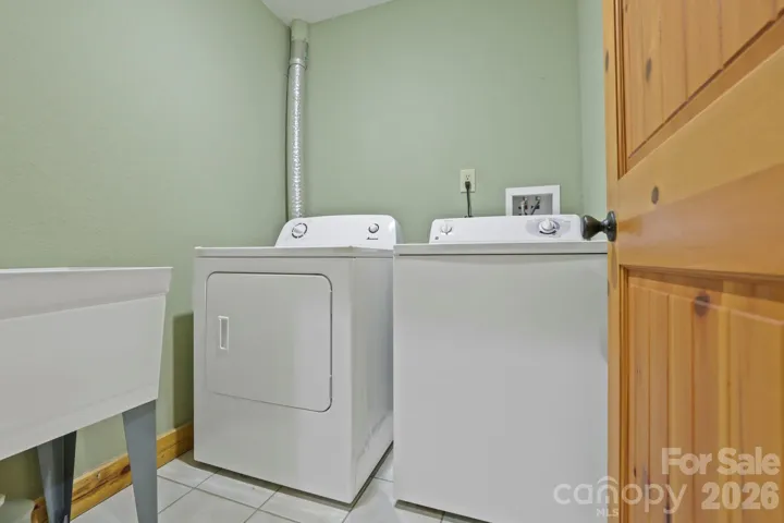 Dedicated laundry area with washer, dryer, and utility sink for added convenience.