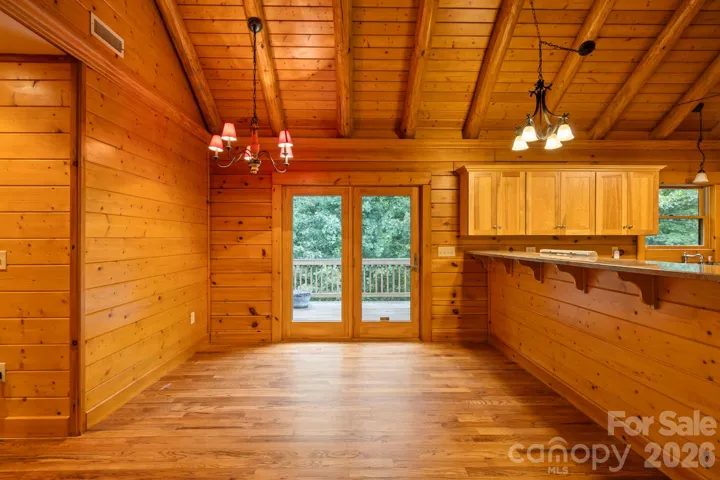 Dining space with direct access to the deck through glass doors, bringing in natural light and easy indoor-outdoor living.
