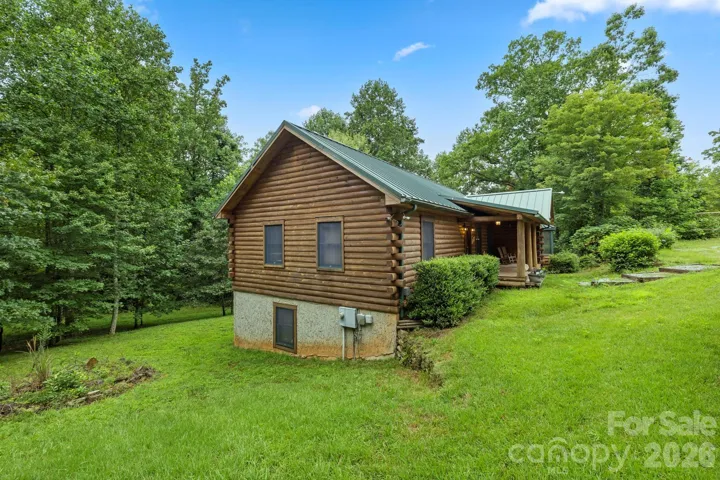 Expansive yard with gentle slopes and mature trees, offering privacy and room to enjoy the outdoors.