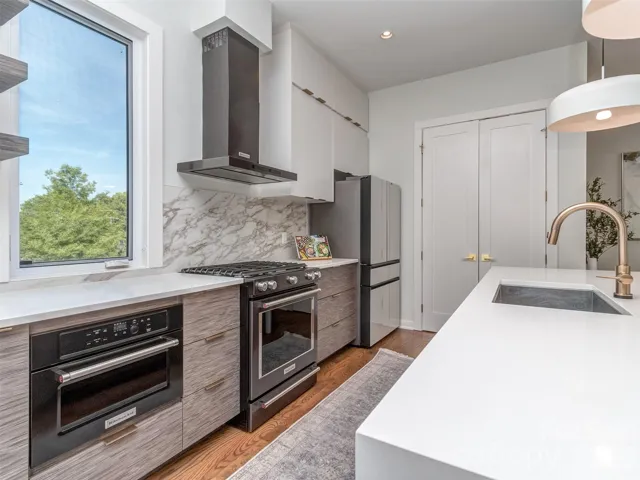 The Gourmet Kitchen is to Die For.  The Island is Quartz with Designer Waterfall Edges.  The Kitchen Also Features Gas Range, Sleek Vent Hood, Pendant Lighting, Quartz Backsplash, Floating Shelves, & The Best View of Chantilly's Tree Lined Neighborhood Street!