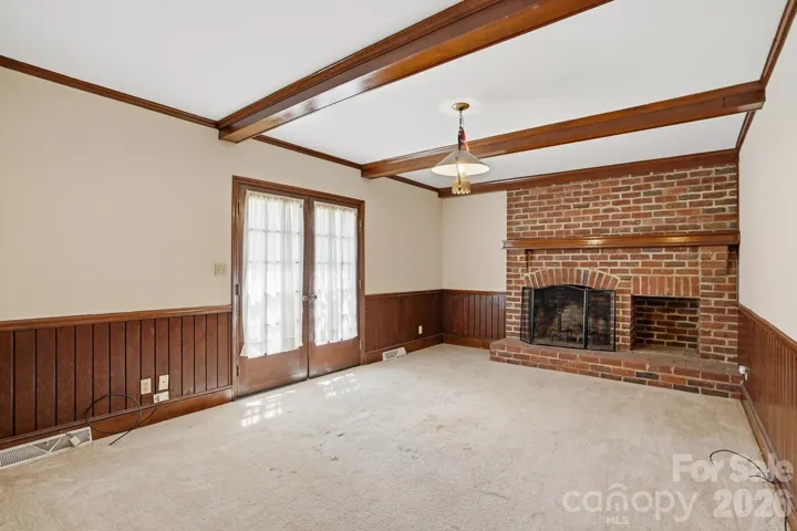 Great room with brick fireplace, molding and beams.  