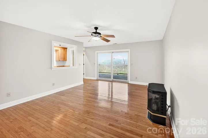 Mid level living room unfurnished with access to rear covered deck offering long range views. 