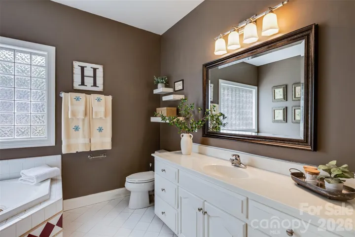 Primary bath en suite offers separate shower and Jacuzzi tub.  Provides great layout & neutral tile.