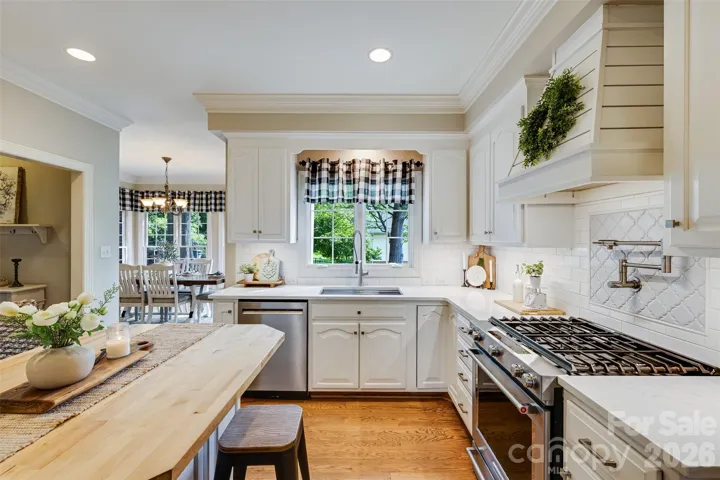 Kitchen with gas range, pot filler & custom hood